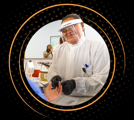 A smiling BioLife healthcare professional in protective gear examining a donor.